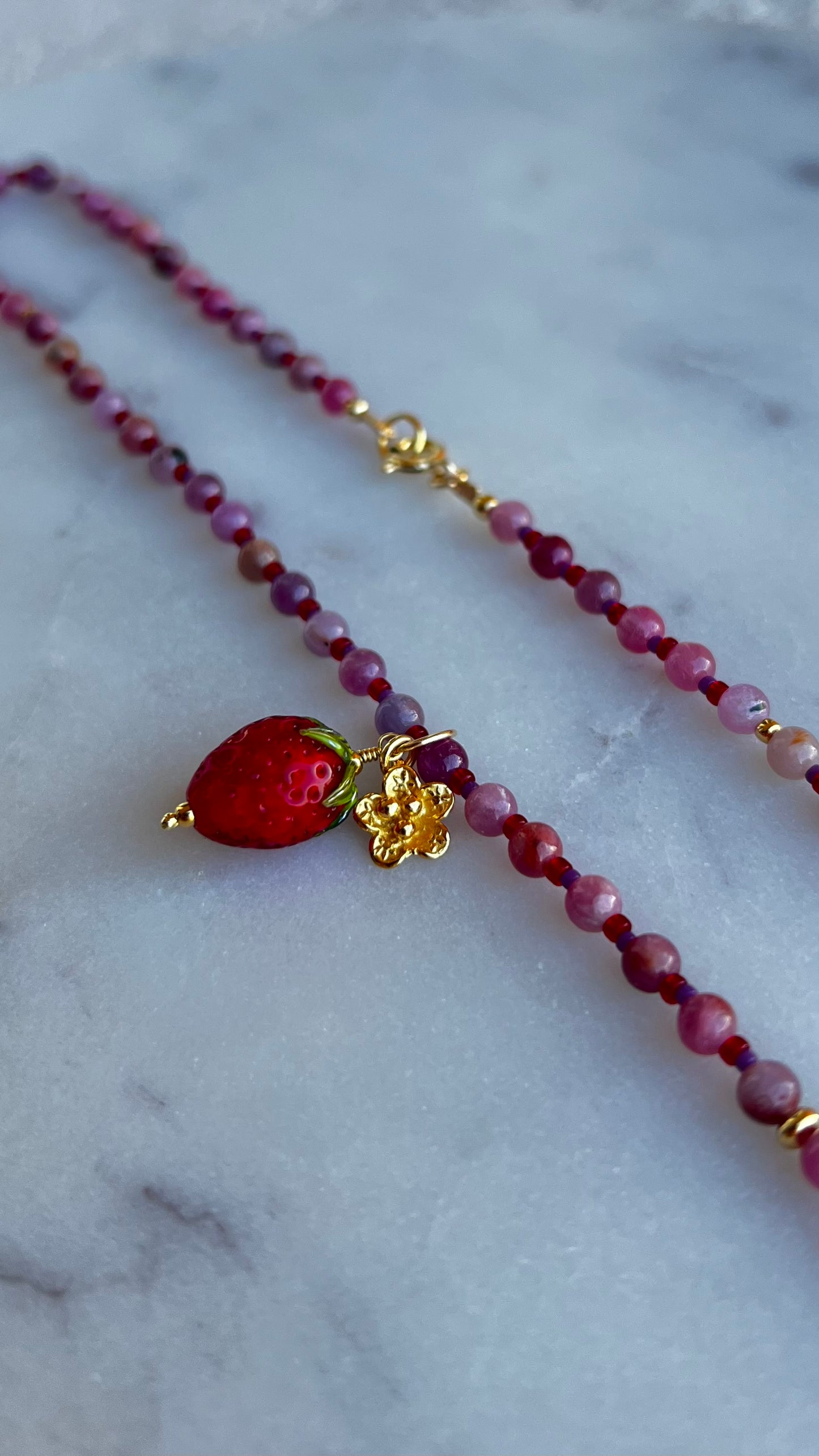 Naszyjnik z rubinu jasnego z truskawką i rozkwitającym kwiatem.